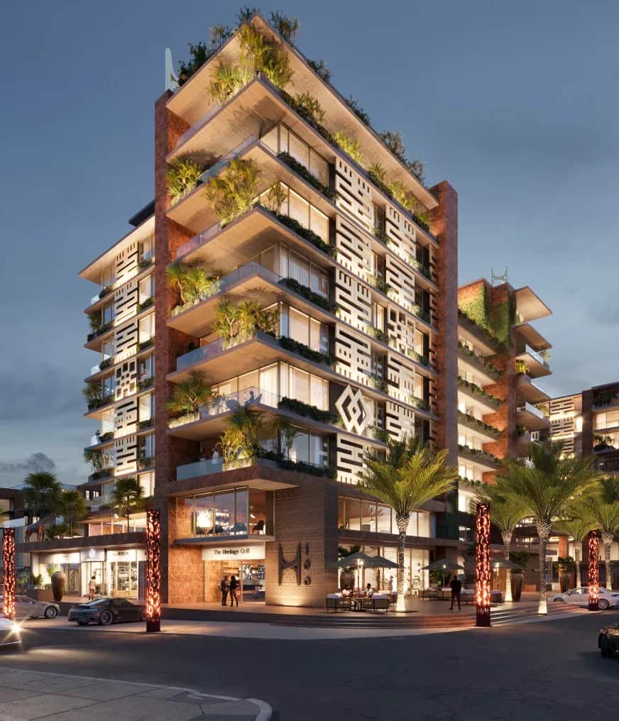 Heritage 100 mixed-use tower at dusk, planted balconies lit from within